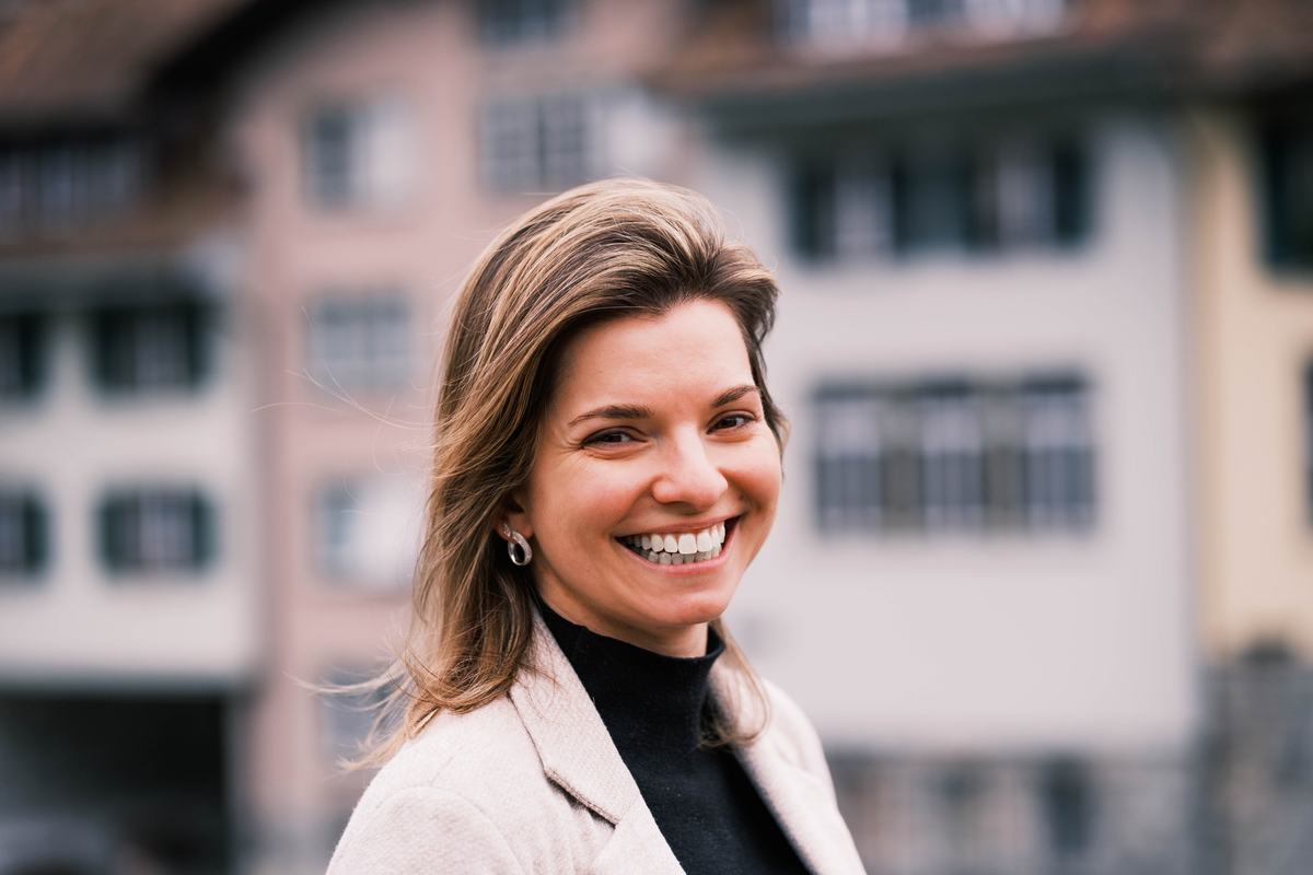 Une femme rit aux éclats devant des façades de vieille ville