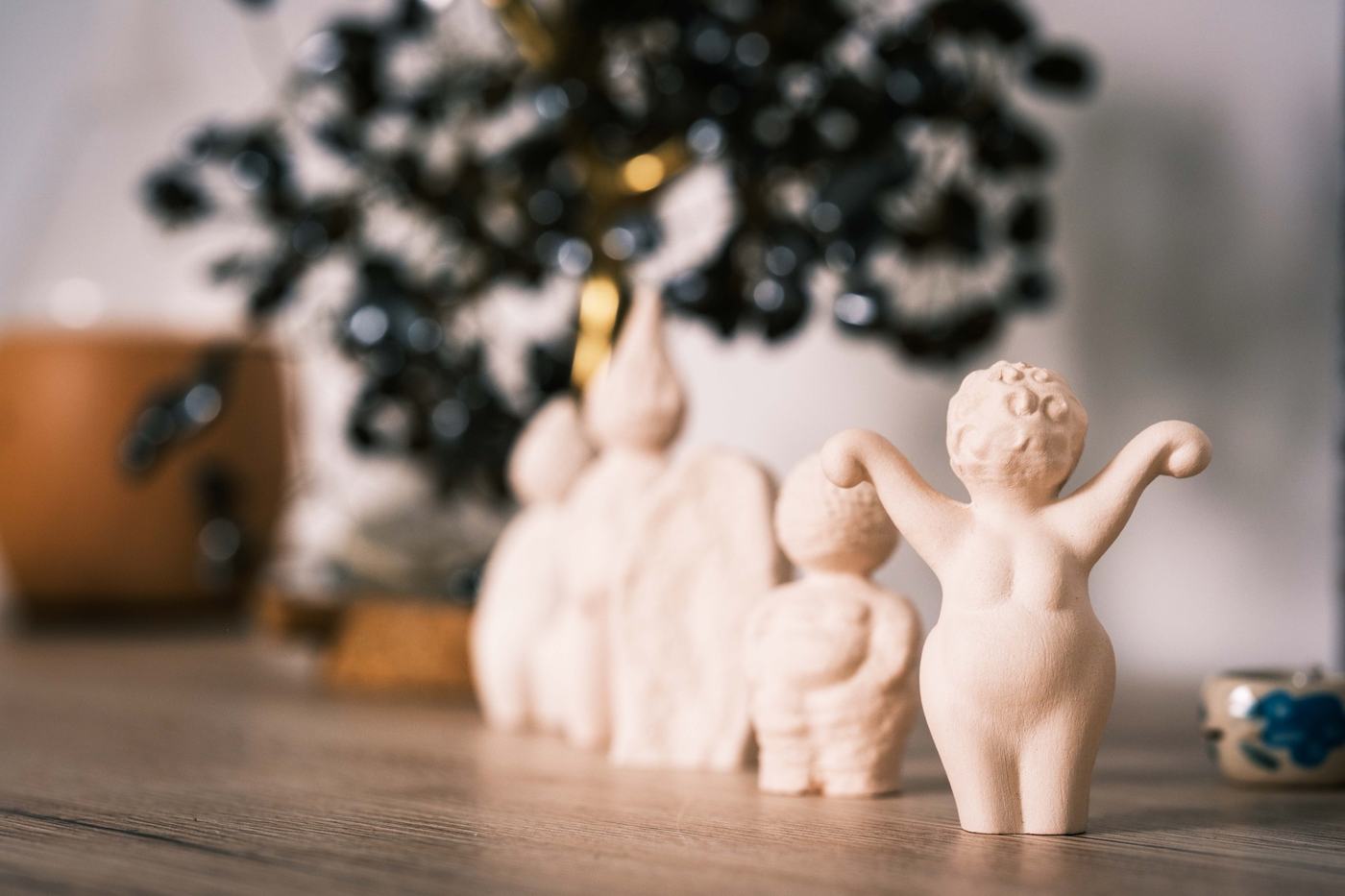 Petites figurines en céramique alignées sur une table en bois