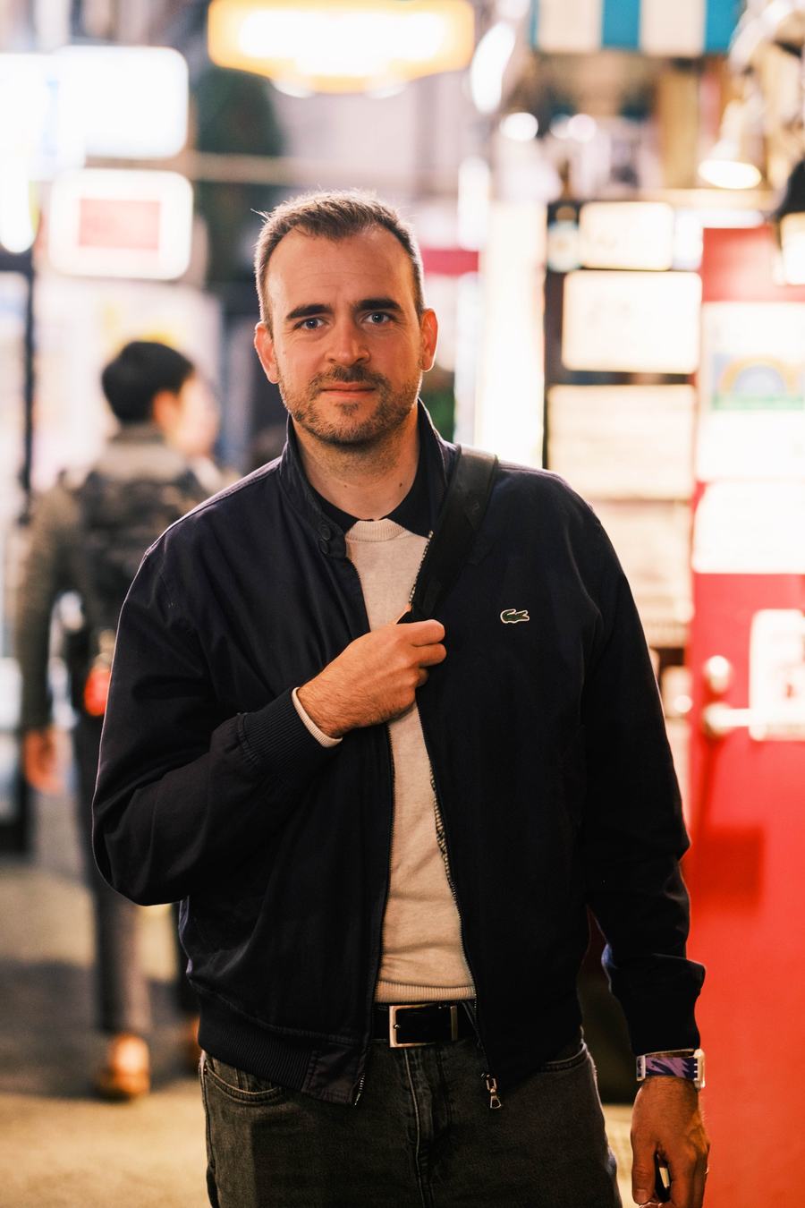 Raphaël Mongeot dans une rue animée, de nuit